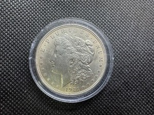 lot 75 image: 1921 Au Morgan Dollar. Honest patina, very light wear.
