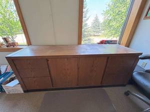 lot 73 image: Large 6.5ft Office Credenza  Great Storage, Solid Build, Shows Wear Spacious and functional with multiple drawers and cabinets. Wood finish has staining and wear but still offers tons of use for office, garage, or storage room.