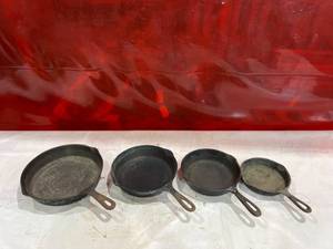 lot 812 image: Four Assorted Cast Iron Skillets Including Wagner and Griswold