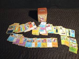 lot 74 image: Pokmon tin filled with 100 Pokmon trading cards