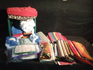 lot 473 image: Laundry basket of kitchen towels and dish cloths, wash cloths, rugs, table cloth and runner and floor scrubber pads, bathmat