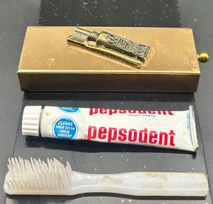 lot 19 image: Mini Vintage Gold Tone Toothpaste and Toothbrush Holder with Pepsodent