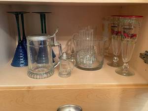 lot 42 image: Collection of Vintage Glassware Set Including Buick Model C Glass, Beer Steins, and Blue Goblets