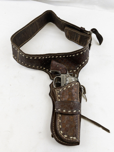 lot 173 image: Vintage Leather Gun Holster Belt with Hubley Cowboy Cap Gun