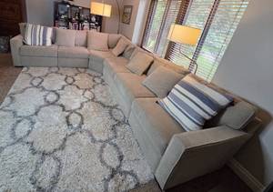 lot 169 image: Large Sectional Sofa with Beige Upholstery and Striped Pillows - Rug Not Inc