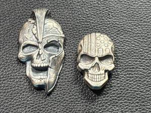 lot 21 image: Two Skull-Shaped Silver Pieces