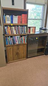 lot 527 image: Brown Wooden Bookshelf with 4 Shelves and Cabinet, Includes Various Books