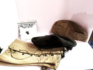 lot 43 image: WWII US Marines Eagle Globe Anchor Lapel Hat Pin, Garrison Cap, Green Wool Crown Service Cap and Canvas Leggings