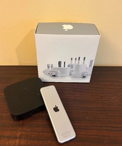 lot 189 image: Apple Helpers Including Apple TV with Remote and Apple Travel Adapters