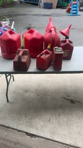 lot 247 image: Assortment of Red Plastic Gas Cans and Metal Gasoline Can