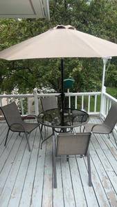 lot 339 image: Patio Set with 4 Chairs, Glass Table, and Tan Umbrella