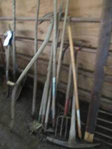 lot 27 image: Bundle of pitchforks, hoes, pickaxe...