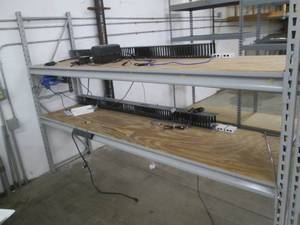 Shelf with some electronics and wiring, as pictured
