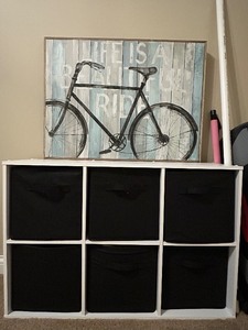 lot 92 image: 6-Cube White Storage Organizer with Black Fabric Bins and Bicycle Wall Art
