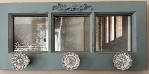lot 45 image: Decorative Wall Mirror with Glass Knob Hooks and Ornate Accent