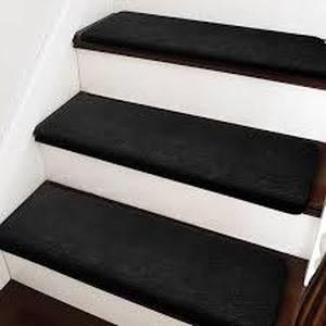 lot 44 image: PURE ERA Black 9.5 in. x 30 in. x 1.2 in. Bullnose Plush Indoor Stair Tread Cover Tape Free Non-slip Carpet Set of 14 Customer Returns See Pictures