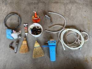 lot 30 image: Mixed Plumbing Parts and Shop Accessories Lot with Hoses, Caulk, and Brooms - quantities unverified