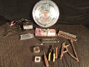 lot 67 image: Motorcycle battery charger, campers repair kit, hub cap clock and tools