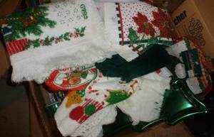 lot 87 image: Box of christmas towels, hot pads, ribbon, cookie trays, tree bag, bell, candle holder, snowman