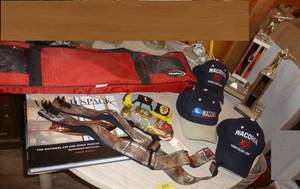 lot 203 image: badmitton net, hats, shooting trophies, camo suspenders, air and space museum book