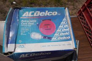 lot 124 image: AC Delco Brand Retractable Cord Reel With 40 Extension Cord and Drop Light