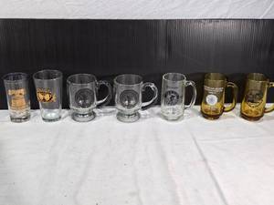 lot 208 image: Glass Mugs and Glasses featuring designs from 1978 American Legion, Nicollet County Fair, and Union Barrel Works, among others