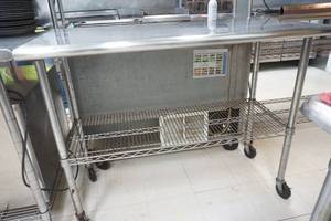 lot 27 image: NSF Stainless Steel Countertop with wire racks on caster wheels