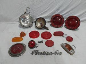 lot 216 image: Assorted Automotive Parts including Broken Pontiac Emblem, Guide R8-50 Light, and Various Lenses