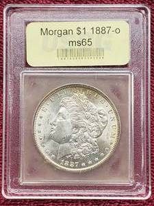 lot 27 image: 1887-O Morgan Silver Dollar, MS 65 in Vintage USCG Slab