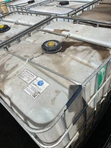 lot 1201 image: Used 275 Gallon Plastic IBC Tote Tank with Metal Cage