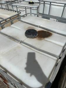 lot 1306 image: Used 275 Gallon IBC Tote Tank with Metal Cage