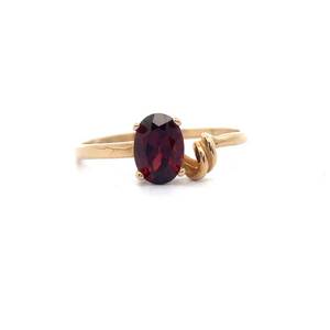 lot 34 image: Oval Red Garnet Love Knot Ring in Yellow Gold
