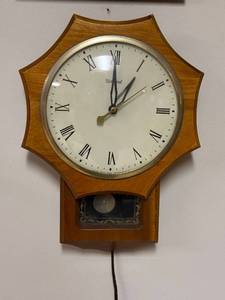 lot 599 image: United Clock Corp Wall Clock with Roman Numerals and Pendulum