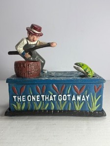 lot 14 image: This classic piece is a must-have for collectors of mechanical banks and unique Americana decor Featuring a charming fisherman theme, this cast iron bank offers both visual appeal and interactive functionality.