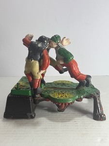 lot 34 image: VINTAGE CALAMITY CAST IRON MECHANICAL COIN BANK - FOOTBALLRUGBY THEME