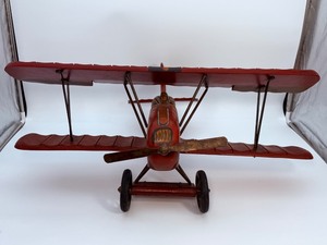 lot 229 image: Large Vintage Hand-Carved Wooden Biplane Model  Folk Art WWI Red Baron Style  Brass Propeller  Metal Spoke Wheels &amp Rubber Tires