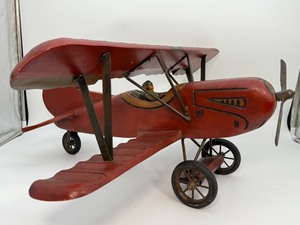 lot 229 image: Large Vintage Hand-Carved Wooden Biplane Model  Folk Art WWI Red Baron Style  Brass Propeller  Metal Spoke Wheels &amp Rubber Tires