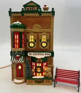 lot 53 image: Department 56 Snow Village The Christmas Shop Handpainted Ceramic Lighted Building with Bench
