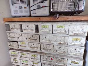 lot 253 image: By Wall TOP- white medal bolt Bin with content -17 drawers