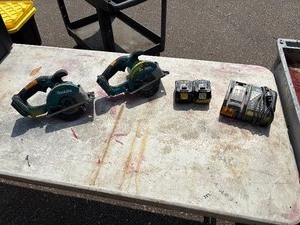 lot 180 image: (2) Makita XSC01 handheld circular saws w (1) 18V 3.0 AH  and (1) 4.0 AH batteries & a DC18RA charger