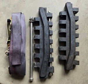 lot 81 image: Over the Tire Track Repair Kit with 2 Rubber Track Pads, Steel Bar, and Ratchet Strap