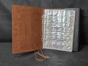 lot 31 image: Nautical-Themed Faux Leather Coin Album Binder with Inserts and Charm Clasp