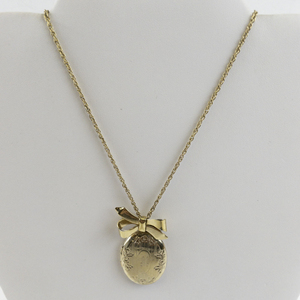 lot 181 image: Gold Tone Base Metal Locket Necklace with Bow Accent