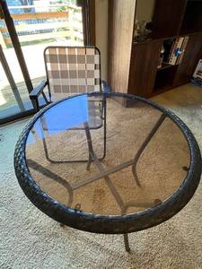 lot 54 image: Round Glass Patio Table with Woven Edge and Folding Chair