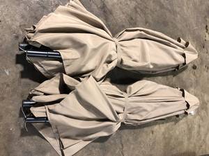 lot 50 image: Lot of Hampton Bay 9 ft. Aluminum Market Crank and Tilt Patio Umbrella in Riverbed Tan  Customer Returns See Pictures