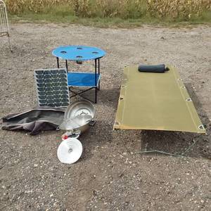 lot 98 image: Solar panel with camping gear including BBQ grill, cot, and table