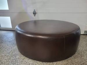 lot 10 image: A Modern Round Brown Leather Coffee Table  Ottoman by Room and Board.