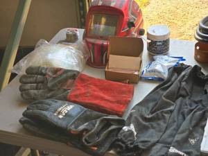 lot 47 image: Welding Protective Gear  Supplies - Gloves (x2 sets), Sleeves (x1 set), Plastic Face Shields (x3), Helmet (x1), Roll of Rosin Solder (x1), Mig Contact Tips, Jar of Nozzle Gel, Plasma Torch