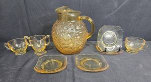 lot 83 image: Amber Depression Glass Pitcher with Cups and Saucers Set