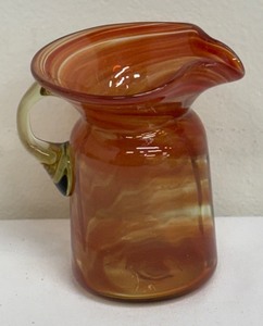 lot 156 image: Petite Orange Swirled Blown Glass Pitcher